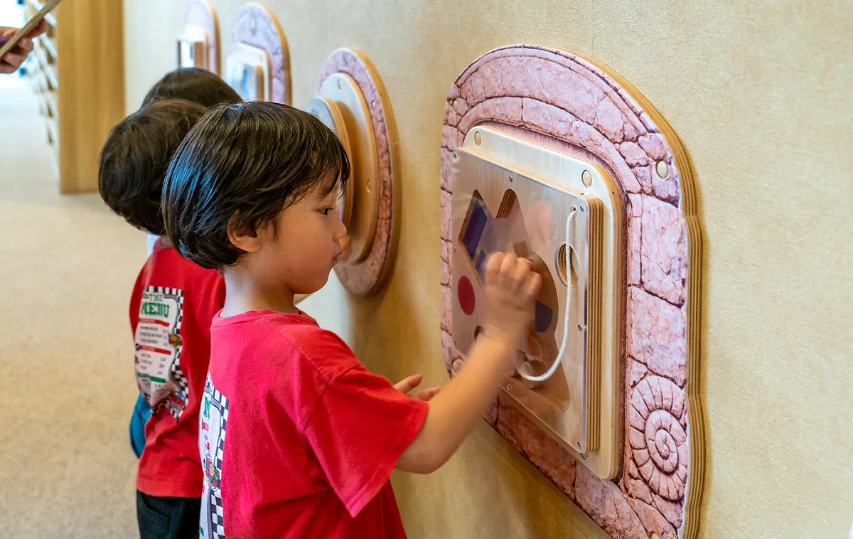 孩子们在KIDS OASIS的墙板上玩耍